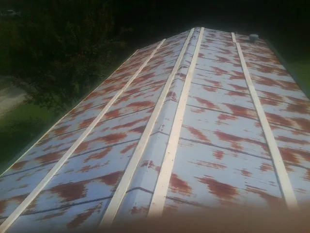 Rusted metal roof panels with new wood purlins before replacement — Storm Damage Roof Repair in Searchlight by Roofing Brothers